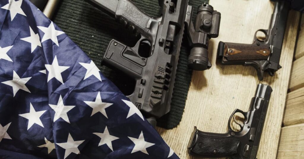 Rifles guns and american flag on table